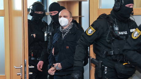 Stephan Balliet, who is accused of shooting dead two people after an attempt to storm a synagogue in Halle an der Saale, wears a face mask as he arrives for the start of the trial at the district court in Magdeburg, Germany, December 21, 2020.