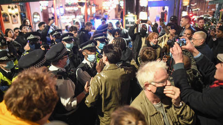 FILE PHOTO: Police officers move crowds in Soho on November 4, 2020 in London, England. Non-essential businesses, including pubs and restaurants, will be forced to close from Thursday, Nov 5, following a new national lockdown in England.
