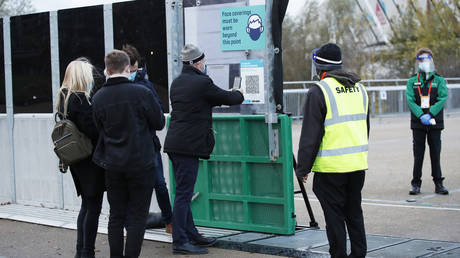 FILE PHOTO: West Ham United fans scan a QR code as they enter the stadium before the match.