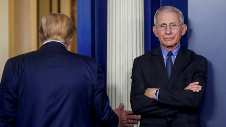 Dr. Anthony Fauci is shown at a White House Covid-19 briefing in March as President Donald Trump is walking away.