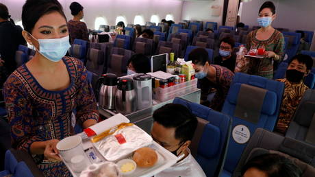 Singapore Airlines stewardesses serve food on board the economy class cabin of their A380 restaurant at Changi Airport in Singapore October 24, 2020.