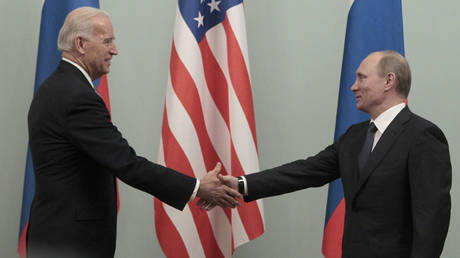 FILE PHOTO: Vladimir Putin (R) shakes hands with Joe Biden during their meeting in Moscow March 10, 2011