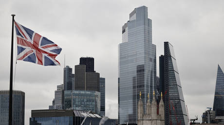 A Union Flag flutters in the wind near office builings in the City of London in London on November 25, 2020.