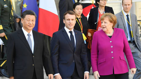 FILE PHOTO: French President Emmanuel Macron (C) accompanies Chinese President Xi Jinping (L) and German Chancellor Angela Merkel (R) after their meeting at the Elysee Presidential Palace on March 26, 2019 in Paris