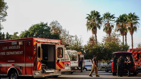 Firefighters and paramedics wait outside LAC + USC Medical Center during a surge of coronavirus cases in Los Angeles, California, December 27, 2020.