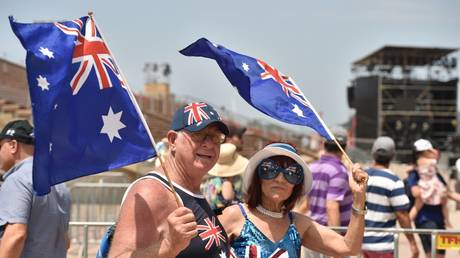 FILE PHOTO: People wave the Australian flag to celebrate Australia Day in Sydney on January 26, 2020 © AFP / Peter Parks