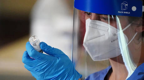 A nurse is shown last week preparing to give a Covid-19 vaccine to an emergency medical worker in New York.