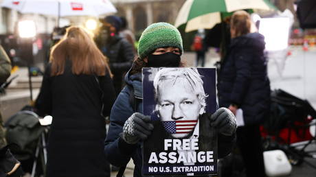A supporter of WikiLeaks founder Julian Assange holds a placard, at the Old Bailey, the Central Criminal Court, in London, Britain, January 4, 2021.
