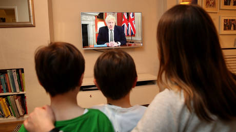 FILE PHOTO: A family in Knutsford, Cheshire, watch Prime Minister Boris Johnson making a televised address to the nation from 10 Downing Street, London, setting out new emergency measures to control the spread of coronavirus in England.