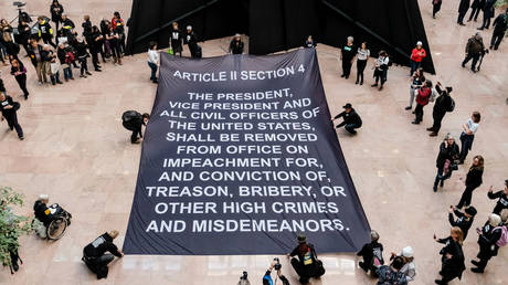 FILE PHOTO: Protesters lay a banner with the Article of Impeachment calling for the removal of President Donald Trump inside of the Hart Senate Office Building during a demonstration on Capitol Hill in Washington, US, January 16, 2020