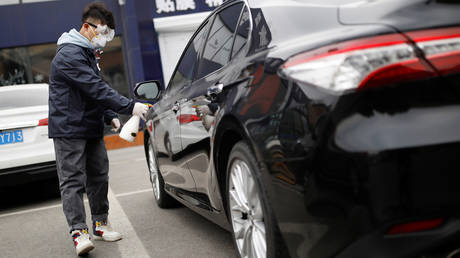 A Didi Chuxing staff member disinfects a vehicle in Beijing. © Reuters / Carlos Garcia Rawlins