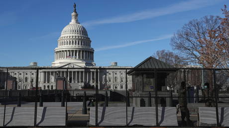 Members of the National Guard stand next to a fence and barricades set up around the US Capitol building in Washington, US, January 9, 2021