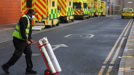 An NHS worker pushes a trolley with the oxygen cylinders (FILE PHOTO) © REUTERS/Simon Dawson