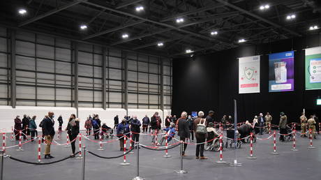 FILE PHOTO: People queue to receive an injection of a Covid-19 vaccine at a NHS mass coronavirus vaccination centre in the Excel Centre in London, Britain. ©  Jeremy Selwyn / Pool via REUTERS