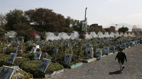 FILE PHOTO: A child walks near graves, including those of Houthi fighters who were killed in this ongoing war, at a cemetery, on January 12, 2021 in Sana'a, Yemen