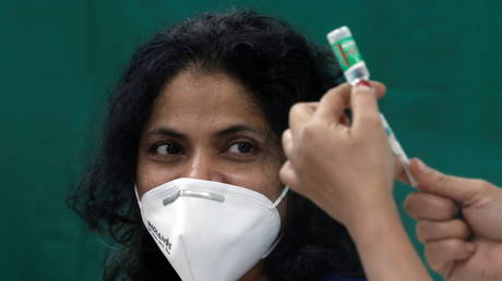 A healthcare worker looks on as a nurse prepares a dose of the AstraZeneca's Covishield vaccine in Mumbai, India, January 16, 2021.