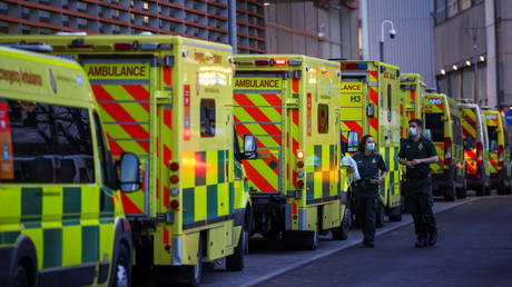NHS workers walk next to a cue of ambulances outside the Royal London Hospital, in London, Britain January 12, 2021. © REUTERS/Henry Nicholls