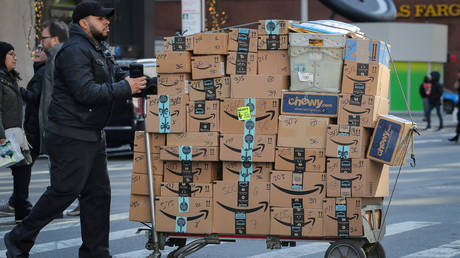 FILE PHOTO: A delivery man pushes a cart full of Amazon boxes in New York City.