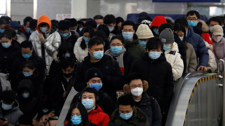Commuters wearing masks at a subway station in Beijing, China, January 20, 2021. © Tingshu Wang / Reuters