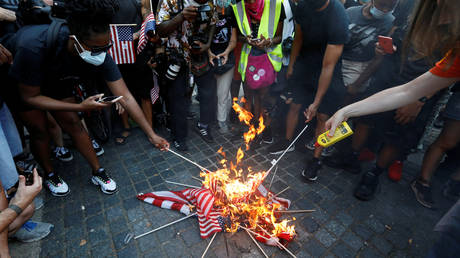 FILE PHOTO: Demonstrators burn U.S. flags during a Black Lives Matter protest on the Fourth of July Holiday in Manhattan, New York City, U.S., July 4, 2020