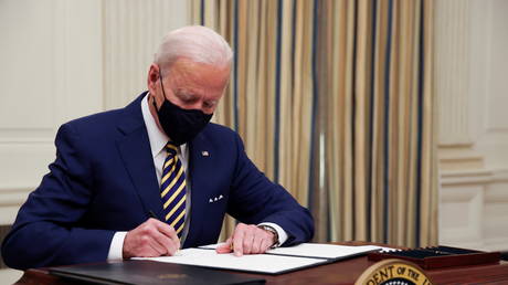 US President Joe Biden signs an executive order after speaking about his administration's plans to respond to the economic crisis during a coronavirus disease (COVID-19) response event in the State Dining Room at the White House in Washington, US, January 22, 2021.