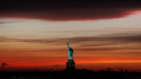 FILE PHOTO: The sun sets behind the Statue of Liberty after a rain storm in New York, U.S., May 15, 2018