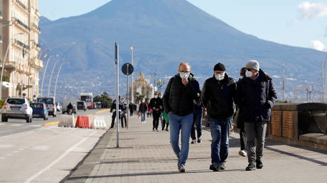 People wearing face masks walk the street, amid the outbreak of the coronavirus disease (COVID-19), in Naples, Italy, January 26, 2021.