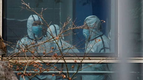 Members of the WHO team don personal protection suits during a visit at the Hubei Animal Epidemic Disease Prevention and Control Center in Wuhan, Hubei province, China February 2, 2021. REUTERS/Thomas Peter