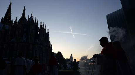 Catholic altar servers swing incense burners as they walk towards the Cologne cathedral during a procession of an Eucharistical Congress in Cologne, western Germany, on June 5, 2013.