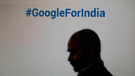 FILE PHOTO. A man walks past a Google hashtag during an event in New Delhi, India.