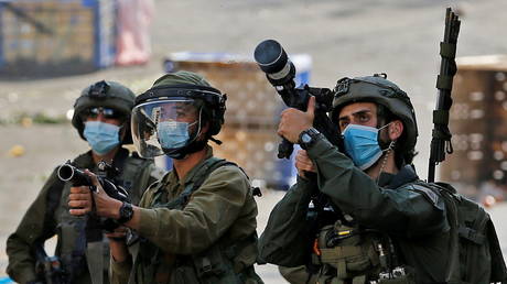 Israeli soldiers in protective masks fire a tear gas canisters towards Palestinian demonstrators. © Reuters / Mussa Qawasma