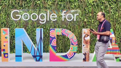 FILE PHOTO. A man walks past the sign of "Google for India" in New Delhi, India.