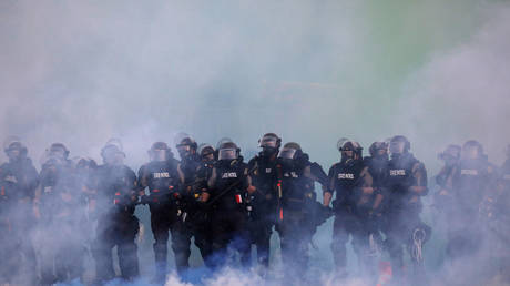 FILE PHOTO: Police officers are seen amid tear gas as protesters continue to rally against the death in Minneapolis police custody of George Floyd, in Minneapolis, Minnesota, U.S. May 30, 2020. © REUTERS/Leah Millis