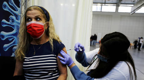 A woman gets vaccinated in Petah Tikva, Israel, January 2021. © Ammar Awad / Reuters