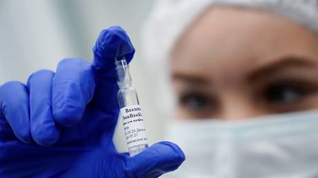 A medical worker holds a vial containing the EpiVacCorona Covid-19 vaccine at a vaccination site in Kaliningrad, Russia, December 2020. © Mikhail Golenkov / Sputnik