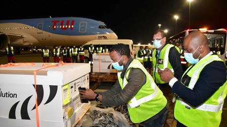 Workers offload pallets containing the first Johnson and Johnson coronavirus disease (COVID-19) vaccine doses as they arrive at OR Tambo airport in Johannesburg, South Africa. February 16, 2021 © Elmond Jiyane for GCIS/Handout via REUTERS.