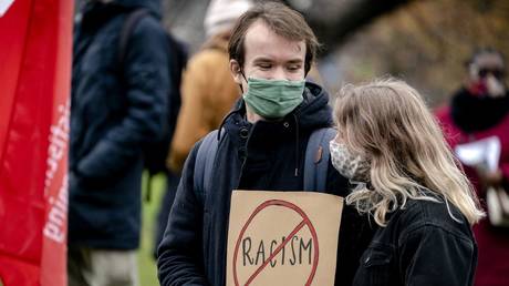FILE PHOTO: A couple holds a placard during a demonstration against racism at the Koekamp park in The Hague, The Netherlands on December 6 2020.