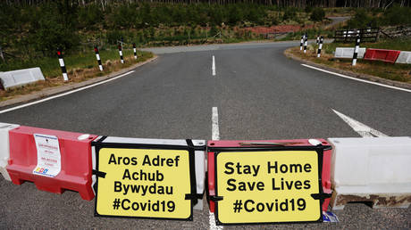 FILE PHOTO: Signs asking people to stay at home are seen near Llwyn-on Reservoir, following the outbreak of the coronavirus disease (COVID-19), Merthyr Tydfil, Wales, Britain, June 2, 2020