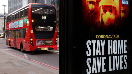 A bus drives past a Government sign about the coronavirus disease in the City of London financial district, Britain, January 8, 2021.