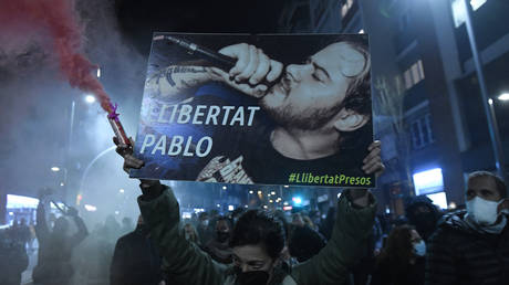 Protesters march with a picture of Spanish rapper Pablo Hasel reading "Freedom to Pablo" during a demonstration in Barcelona against his arrest on February 16, 2021.