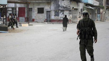 Members of al Qaeda's Nusra Front walk along a street in the northwestern city of Ariha, after a coalition of insurgent groups seized the area in Idlib province May 29, 2015.