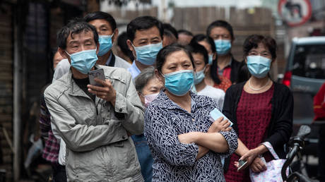 Residents wait in line to provide swab samples to be tested for the COVID-19 coronavirus, in a street in Wuhan, China © STR / AFP