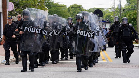 FILE PHOTO: Police officers clad in riot gear prepare to face down opposing protesters at a Confederate memorial at Stone Mountain, Georgia.