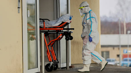 FILE PHOTO: A member of the medical staff enters a hospital to transfer a patient suffering from coronavirus disease (COVID-19) from the fully occupied Cheb hospital in the town of Cheb, Czech Republic, February 22, 2021. © REUTERS/David W Cerny