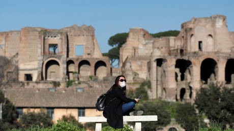 A woman sits at Circo Massimo during a sunny day amid the Covid outbreak in Rome, Italy on March 2, 2021 © REUTERS/Yara Nardi