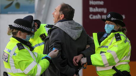 FILE PHOTO. Police handcuff a demonstrator during a protest against the lockdown. ©REUTERS / Simon Dawson