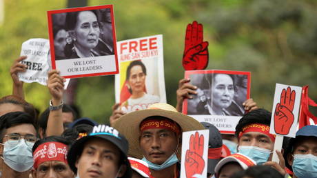 Demonstrators hold placards with pictures of Aung San Suu Kyi as they protest against the military coup in Yangon, Myanmar, (FILE PHOTO) © REUTERS/Stringer