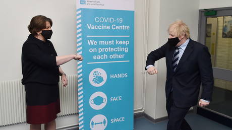 British Prime Minister Boris Johnson is greeted by Northern Ireland First Minister Arlene Foster at the Lakeland Forum COVID-19 vaccination centre in Enniskillen, Northern Ireland, March, 12, 2021