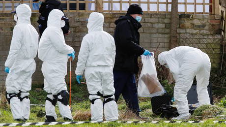 Police officers search an area of grass land behind a house, as the investigation into the disappearance of Sarah Everard continues, in Deal, Britain, March 12, 2021. © REUTERS/Paul Childs