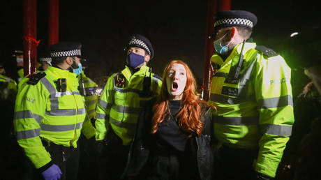 Police detain a woman as people gather at a memorial site in Clapham Common Bandstand, following the kidnap and murder of Sarah Everard, in London, Britain March 13, 2021.  © REUTERS/Hannah McKay